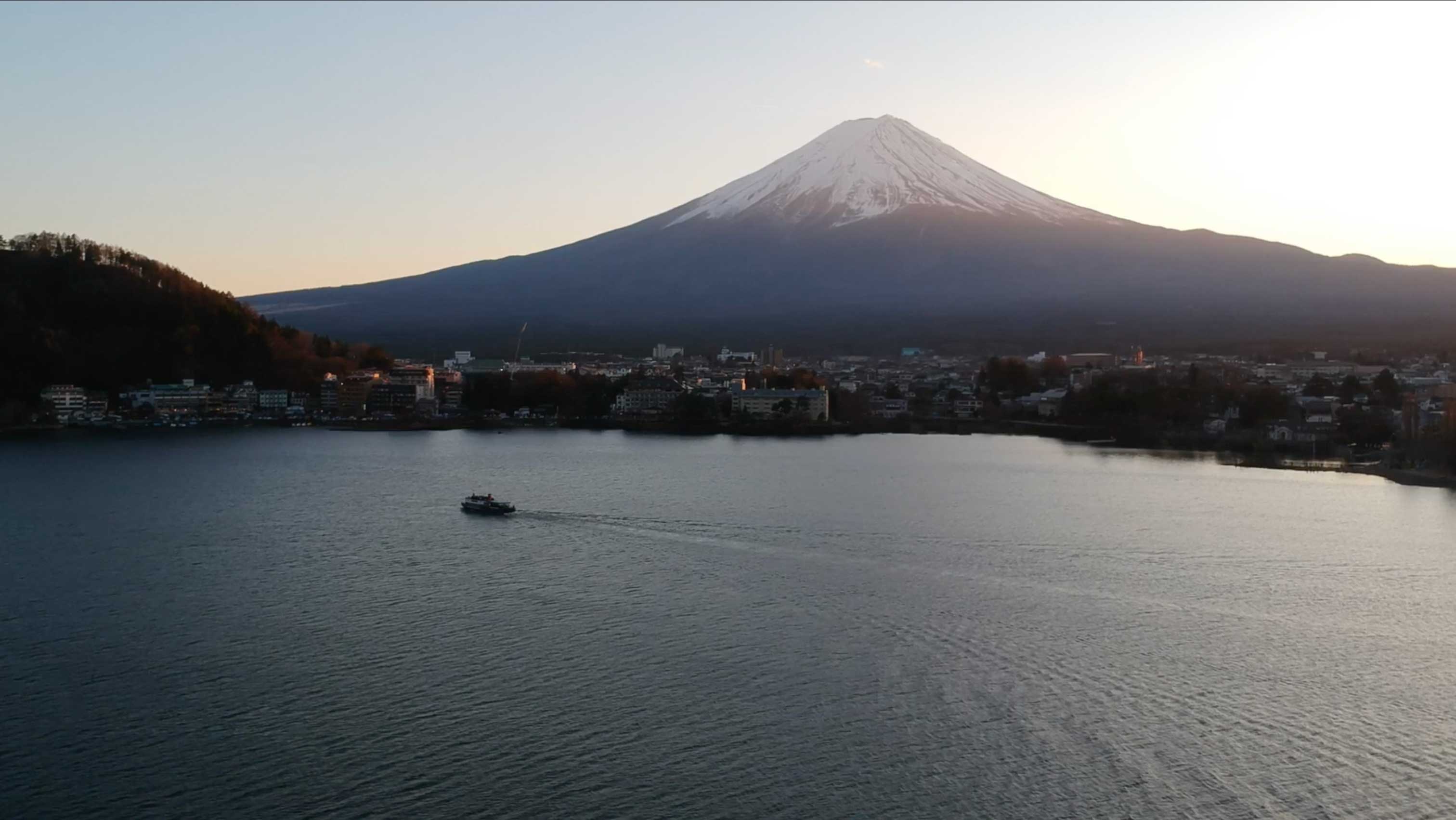 A drone image of a Japanese landscape with a lake and Mount Fuji in the background